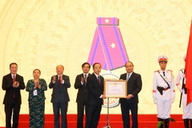 Thủ tướng Nguyễn Xuân Phúc trao tặng Huân chương Lao động hạng Ba cho Hiệp hội Doanh nghiệp nhỏ và vừa Việt Nam. (Ảnh: Thống Nhất/TTXVN)