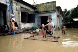 Người dân thôn Huỳnh Kim, phường Nhơn Hòa, thị xã An Nhơn, Bình Định làm vệ sinh nhà cửa khi nước vừa rút xuống. (Ảnh: Nguyên Linh/TTXVN)