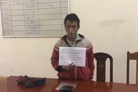 Đối tượng Sùng A Lùng cùng tang vật bị bắt tại cơ quan điều tra. (Ảnh: Xuân Tiến/TTXVN)