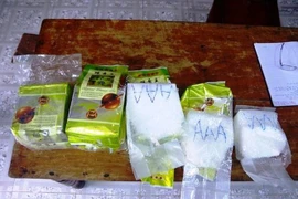 Lực lượng Biên phòng tỉnh Thừa Thiên-Huế tiếp nhận những gói chứa chất tinh thể màu trắng đục, nghi ma túy đá từ người dân. (Ảnh: TTXVN)