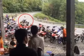 Nam thanh niên điều khiển xe máy Exiter màu xám dừng trên đèo sau màu bốc đầu xe. (Ảnh cắt từ clip)