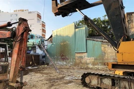Trong quá trình thi công khách sạn, cần cẩu gặp trục trặc khiến cần khoan đổ sập vào nhà dân. (Ảnh: Nguyên Linh/TTXVN)