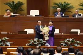 Chủ tịch Quốc hội Nguyễn Thị Kim Ngân tặng hoa cho ông Nguyễn Khắc Định. (Ảnh: Dương Giang/TTXVN)
