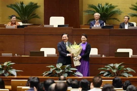 Chủ tịch Quốc hội Nguyễn Thị Kim Ngân tặng hoa cho ông Nguyễn Khắc Định. (Ảnh: Dương Giang/TTXVN)