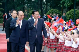 Thủ tướng Chính phủ Nguyễn Xuân Phúc đón và Thủ tướng Vương quốc Campuchia Samdech Techo Hun Sen với thiếu nhi Thủ đô Hà Nội tại Lễ đón. (Ảnh: Thống Nhất/TTXVN)