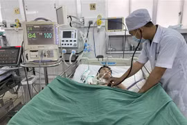 Bác sỹ kiểm tra cho bệnh nhân sau can thiệp. (Ảnh: TTXVN)