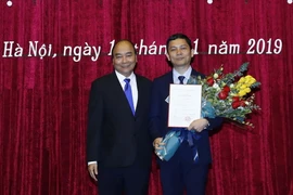 Thủ tướng Nguyễn Xuân Phúc chúc mừng phó giáo sư-tiến sỹ Bùi Nhật Quang. (Ảnh: Thống Nhất/TTXVN)