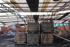 Những thùng dầu trên xe tải được xác định là phương tiện liên quan việc xả chất thải. (Ảnh: Vũ Hà/TTXVN)