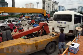 Di chuyển xe vi phạm tại một bến cóc ở khu vực gần bến xe Mỹ Đình. (Ảnh: Huy Hùng/TTXVN)