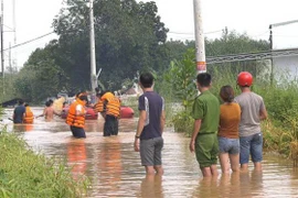 Lực lượng chức năng giải cứu người dân ra khỏi khu vực nguy hiểm. (Ảnh: Đậu Tất Thành/TTXVN)