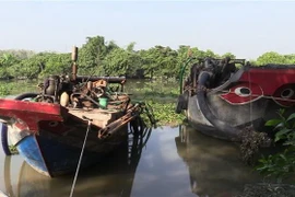 Ghe hút cát lậu tại hiện trường. (Ảnh: Nguyễn Văn Việt/TTXVN)