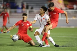 Tiền đạo Đức Chinh bị 2 hậu vệ Singapore kèm sát. (Ảnh: Hoàng Linh/TTXVN)