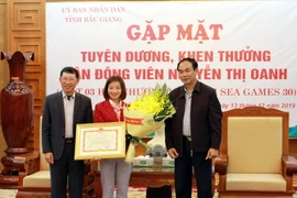 Lãnh đạo tỉnh Bắc Giang trao tặng bằng khen cho vận động viên Nguyễn Thị Oanh. (Ảnh: Đồng Thúy/TTXVN)