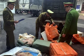 Lực lượng chức kiểm kê số sản phẩm động vật không rõ nguồn gốc thu giữ được. (Ảnh: Đồng Thúy/TTXVN)
