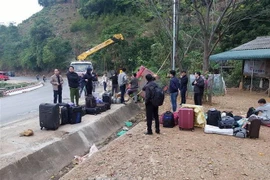 Hành khách đi trên xe và hành lý được đưa ra ngoài. (Ảnh: TTXVN)