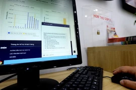 Khách hàng có thể thực hiện những giao dịch về dịch vụ điện qua các thiết bị điện tử (ảnh chụp tại Phòng giao dịch khách hàng Công ty Điện lực Hoàn Kiếm, Hà Nội). (Ảnh: Ngọc Hà/TTXVN)