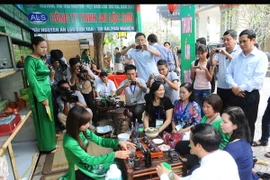 Khách tham quan thưởng thức hương vị Trà tại gian hàng. (Ảnh: Minh Đức/TTXVN)