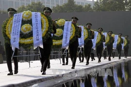 Binh sĩ Trung Quốc đặt hoa tại lễ tưởng niệm các nạn nhân vụ thảm sát Nam Kinh tại Bảo tàng tưởng niệm cuộc thảm sát Nam Kinh. THX-TTXVN