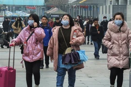 Hành khách đeo khẩu trang khi di chuyển tại một nhà ga ở Hồ Bắc, Trung Quốc để phòng tránh lây nhiễm dịch bệnh viêm phổi do virus corona ngày 21/1/2020. (Ảnh: AFP/TTXVN)