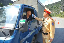 Cảnh sát giao thông huyện Hoa Lư, Ninh Bình kiểm tra nồng độ cồn của lái xe. (Ảnh: Minh Đức/TTXVN)