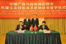 Phó Thủ tướng Nguyễn Xuân Phúc chứng kiến Lễ ký Thỏa thuận thiết lập quan hệ hữu nghị giữa Thành phố Hồ Chí Minh và Khu tự trị dân tộc Choang Quảng Tây ngày 17/9. (Ảnh: Trung Kiên/TTXVN)