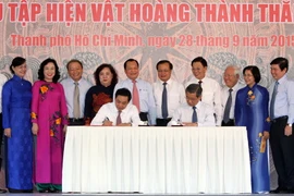 Các lãnh đạo Thành phố Hồ Chí Minh và Hà Nội ký bàn giao “Hiện vật Hoàng thành Thăng Long." (Ảnh: Phương Vy/TTXVN)