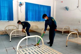 Lực lượng dân quân tự vệ địa phương dọn dẹp điểm cách ly tập trung tại Trường THPT Thốt Nốt (Cần Thơ) chuẩn bị đón người dân vào cách ly. (Ảnh: Thu Hiền/TXVN)