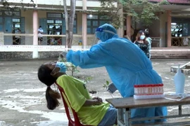 Lấy mẫu xét nghiệp đối với các trường hợp liên quan đến chùm ca bệnh 5 người trong một gia đình tại Kon Tum. (Ảnh: TTXVN phát)