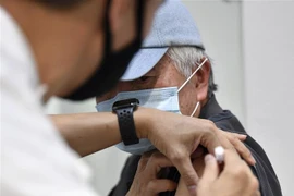 Nhân viên y tế tiêm vaccine phòng COVID-19 cho người dân tại Sydney, Australia, ngày 17/8/2021. (Ảnh: AFP/ TTXVN)