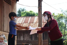 Cô Lê Thị Tuyến, giáo viên lớp 2A, trường Tiểu học Ama Trang Lơng, xã Cư Mgar, huyện Cư M'gar (Đắk Lắk) giao và hướng dẫn bài tại nhà cho học sinh. (Ảnh minh họa: Tuấn Anh/TTXVN)