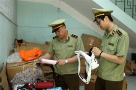 Đội quản lý thị trường thành phố Lào Cai kiểm tra các mặt hàng vừa được thu giữ. (Ảnh: Quốc Khánh/TTXVN)