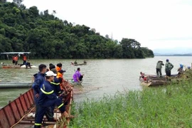 Lực lượng chức năng huy động phương tiện của những hộ dân sinh sống quanh khu vực lòng hồ thủy điện Plei Krông (thôn 3, xã Hà Mòn, huyện Đăk Hà, tỉnh Kon Tum) để tìm kiếm 2 nạn nhân bị mất tích. (Ảnh: Khoa Chương/TTXVN)