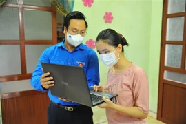 Phó Bí thư Thành đoàn Hà Nội Trần Quang Hưng trao tặng máy tính và túi an sinh cho cháu Nguyễn Thị Thu Phương có hoàn cảnh khó khăn tại huyện Thường Tín. (Ảnh: Minh Đức/TTXVN)