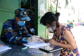 Bà Thái Thị Nguyệt Thanh, trọ tại 429/10C Lê Văn Sỹ, phường 12, Quận 3, TP.HCM ký nhận tiền hỗ trợ đợt 3. (Ảnh: Thanh Vũ/TTXVN)