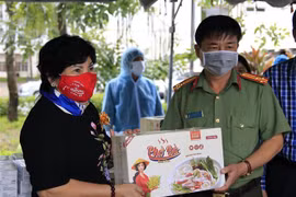 Bà Lê Thị Giàu, Chủ tịch Hội đồng quản trị Công ty Cổ phần Thực phẩm Bình Tây trao quà cho lực lượng làm nhiệm vụ tại khu cách ly tập trung tại Trường Đại học An Giang. (Ảnh: Thanh Sang/TTXVN)