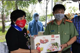 Bà Lê Thị Giàu, Chủ tịch Hội đồng quản trị Công ty Cổ phần Thực phẩm Bình Tây trao quà cho lực lượng làm nhiệm vụ tại khu cách ly tập trung tại Trường Đại học An Giang. (Ảnh: Thanh Sang/TTXVN)