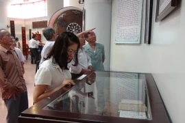 Các đại biểu tham quan trưng bày tư liệu di vật của gia tộc Nguyễn Du tại Bảo tàng tỉnh Bắc Ninh. (Ảnh: Thái Hùng/TTXVN)