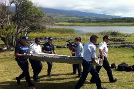 Chuyển mảnh vỡ máy bay được nghi là của MH370 trên đảo Reunion ngày 29/7. (Nguồn: AFP/TTXVN)