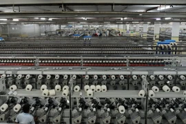 Công nhân làm việc tại nhà máy dệt ở làng Khatraj, cách Ahmedabad, bang Gujarat khoảng 20km ngày 8/7. (Nguồn: AFP/TTXVN)