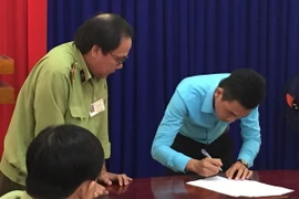 Cơ sở vi phạm ký Biên bản xử phạt vi phạm hành chính. (Ảnh: Huỳnh Kim Phượng/TTXVN)