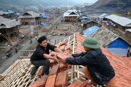Một gia đình ở bản Na Lát dựng nhà mới tại điểm tái định cư Nậm Cản, thị xã Mường Lay. (Ảnh: Xuân Trường/TTXVN)