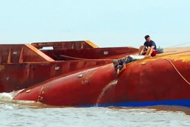 Lực lượng cứu hộ triển khai hàn cắt, phá lớp vỏ tàu để tìm kiếm 4 người còn mất tích. (Ảnh: Mạnh Linh/TTXVN)