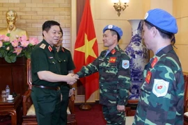 Trung tướng Nguyễn Trọng Nghĩa (trái) chúc mừng Trung tá Mạc Đức Trọng và Trung tá Trần Nam Ngạn lên đường làm nhiệm vụ tham gia lực lượng gìn giữ hòa bình LHQ. (Ảnh: Nguyễn Hồng Pha/Thông tấn quân sự)