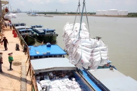 Bốc xếp mặt hàng gạo xuất khẩu sang thị trường Philippines tại cảng Nhà Bè (TP Hồ Chí Minh). (Ảnh: Đình Huệ/TTXVN)