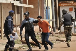 Lực lượng an ninh Mali sơ tán con tin vừa được giải cứu tại khách sạn Radisson Blu ngày 20/11. (Nguồn: AFP/TTXVN)