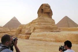 Tượng Nhân sư bên cạnh kim tự tháp Menkaure (phải) và Khafre (trái) tại Giza, ngoại ô thủ đô Cairo ngày 9/11. (Nguồn: Kyodo/TTXVN)