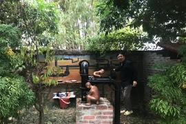 Thứ trưởng Vương Duy Biên bên tác phẩm yêu thích. (Ảnh: Mỹ Bình/Vietnam+)