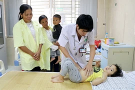 Bác sỹ Trung tâm Y tế huyện Cẩm Khê thăm khám cho cháu Nguyễn Khánh Ly, 3 tuổi, ở khu 4 xã Hương Lung. (Ảnh: Trung Kiên/TTXVN)