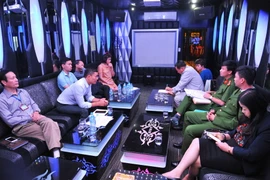 Đoàn kiểm tra liên ngành kiểm tra giấy phép kinh doanh của quán karaoke Bích Thái tại địa chỉ 139 Bùi Thị Xuân. (Ảnh: Minh Đức/TTXVN)