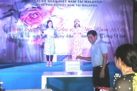 Đại sứ Việt Nam tại Malaysia Lê Quý Quỳnh quyên góp ủng hộ đồng bào vùng lũ. (Ảnh: Hoàng Nhương/Vietnam+)